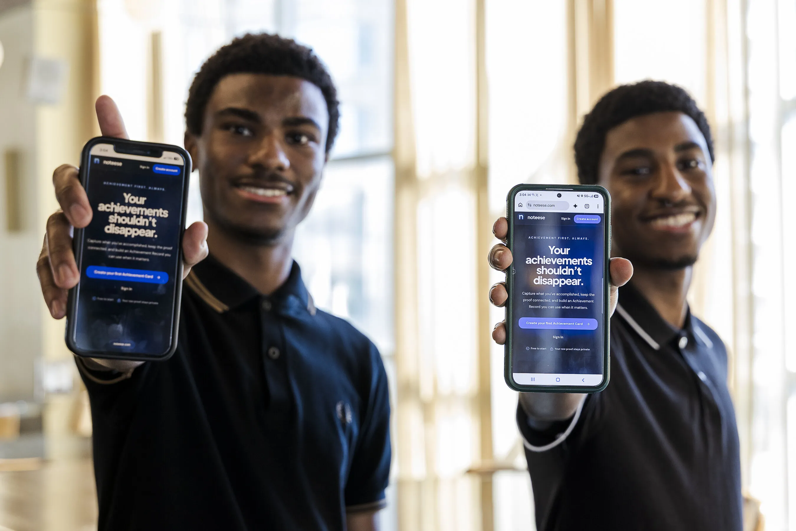 Two men hold smartphones displaying an achievement card website.