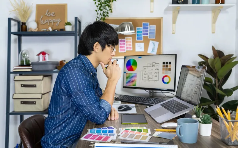 A freelance designer at his desk with colour swatches